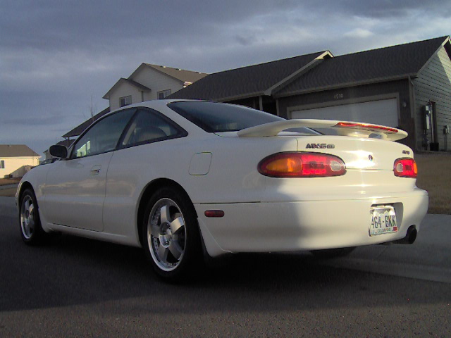 White coupe with a rear spoiler and a license plate reading 464-EKK