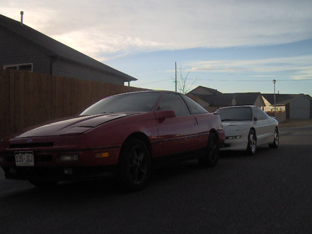 Red and white Ford Probe cars parked side-by-side on a street