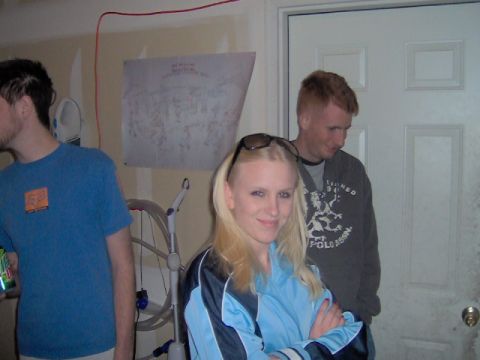 1996 Ford Probe - A group of people are gathered inside a garage, with a poster visible on the wall.