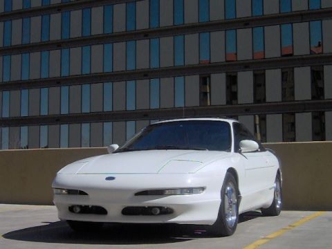 1996 Ford Probe - This 1996 Ford Probe is captured in a three-quarter front view, its coupe body style against a backdrop of a contemporary building.