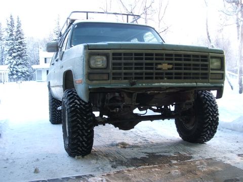 1990 Chevrolet Suburban - This 1990 Chevrolet Suburban is equipped with large off-road tires and a roof rack, seen here in a snowy environment.