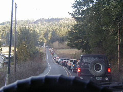 1994 Ford Explorer - Traffic jam of SUVs and trucks on a rural road surrounded by trees and hills.
