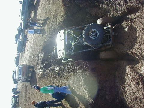 1994 Ford Explorer - Multiple vehicles and spectators at a muddy off-road event.