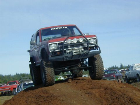 1994 Ford Explorer - This modified SUV navigates a challenging dirt obstacle during an event.