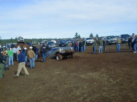1994 Ford Explorer - A 1994 Ford Explorer is stuck in the mud at an event with many spectators and other vehicles present.