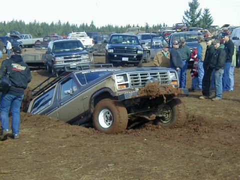 1994 Ford Explorer - A Ford Bronco is stuck in a mud pit during an event, with spectators gathered around.