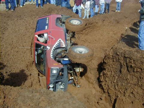 1994 Ford Explorer - An off-road vehicle has become stuck and overturned in a muddy ditch during an event.