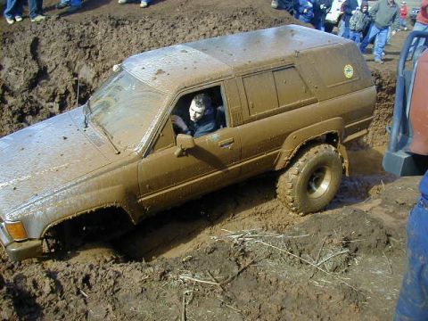 1994 Ford Explorer - A driver navigates an off-road vehicle through a challenging mud bog during an event.
