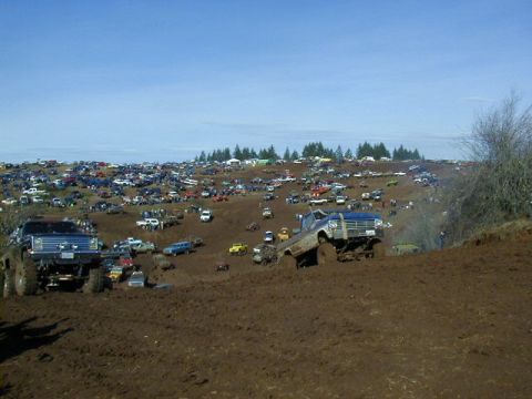 1994 Ford Explorer - A large gathering of off-road vehicles on a muddy terrain during an event.