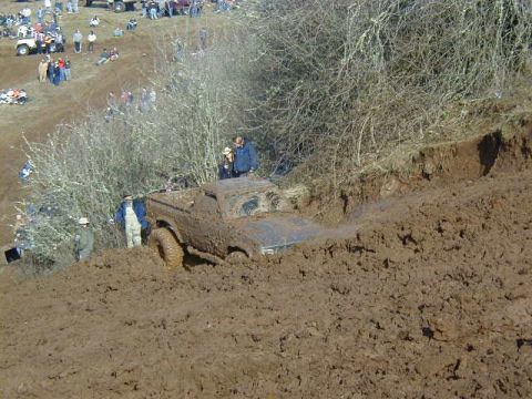 1994 Ford Explorer - A truck is stuck in a deep mud pit while onlookers observe from the side.