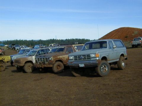 1994 Ford Explorer - This light blue SUV, likely a 1992 model, is equipped for off-road adventures and parked in a muddy lot.
