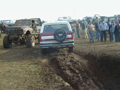 1994 Ford Explorer - Off-road vehicles covered in mud during an event, with onlookers observing the action.