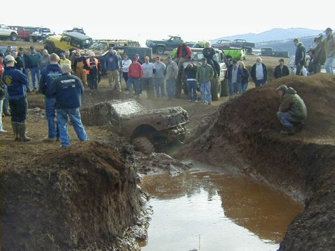 1994 Ford Explorer - Spectators watch as off-road vehicles navigate a muddy obstacle course.