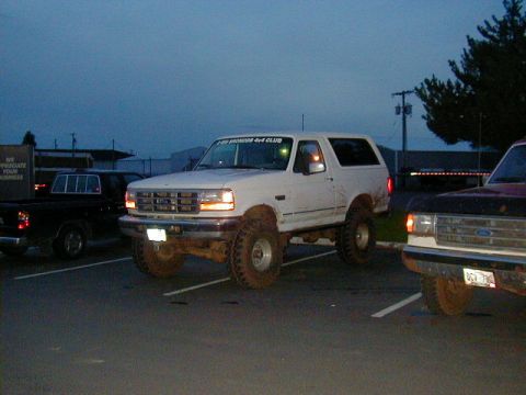 1994 Ford Explorer - A white Ford Bronco with a sticker on the windshield is parked in a lot next to another vehicle.