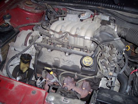 1999 Ford Taurus - The engine bay of a 1999 Ford Taurus, clearly showing the V6 engine configuration.