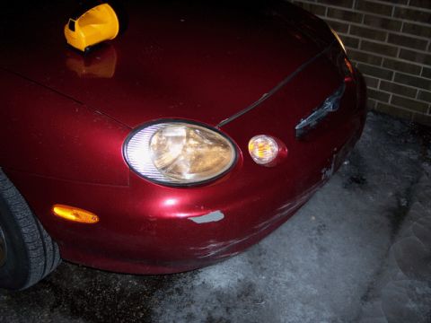 1999 Ford Taurus - Close-up of a red car's headlight and front fender.