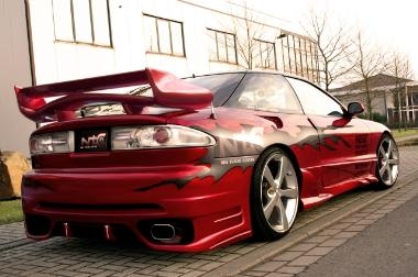 1995 Ford Probe - Customized red sports car with flame decals and aftermarket wheels.
