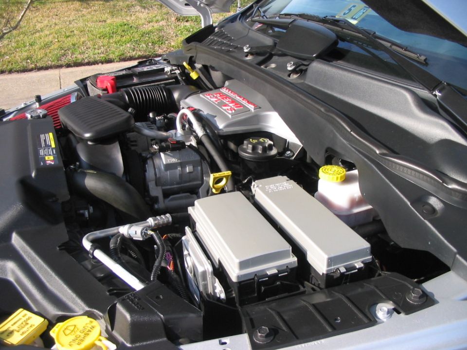 Engine bay showing fuse box, coolant reservoir, and Hemi intake, hood open