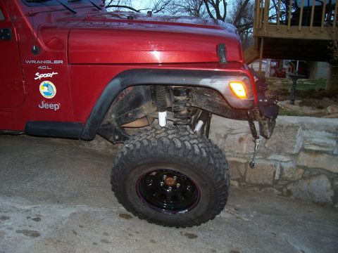 1998 Jeep TJ - This red 1998 Jeep TJ Wrangler Sport features a 4.0L engine and is equipped with a lift kit and oversized tires.