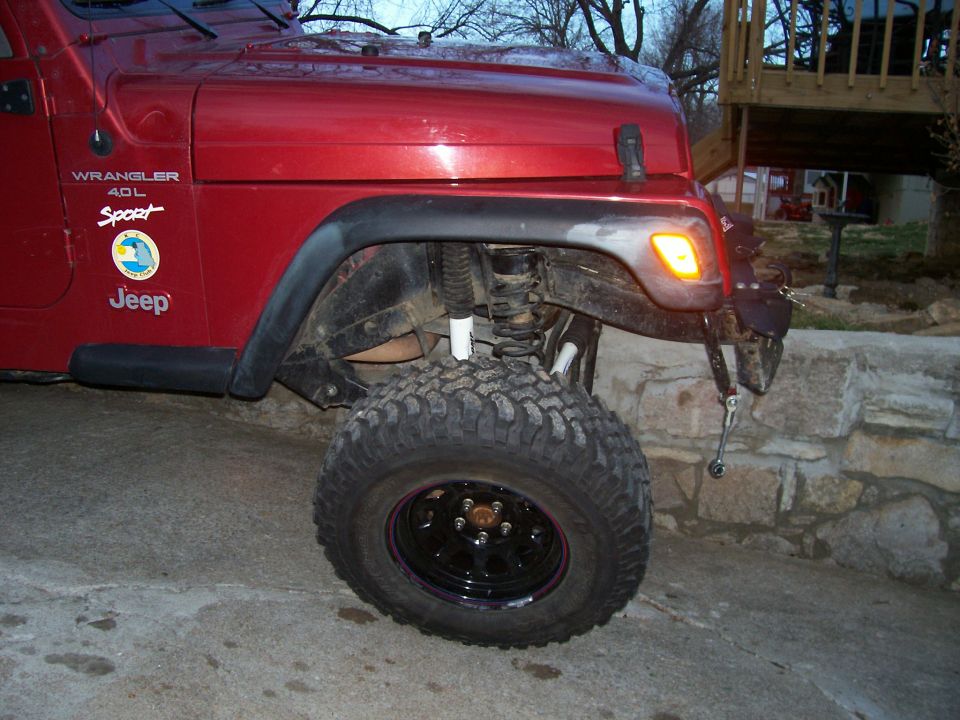 Red 1998 Jeep TJ Wrangler 4.0L Sport with lifted suspension and large tires