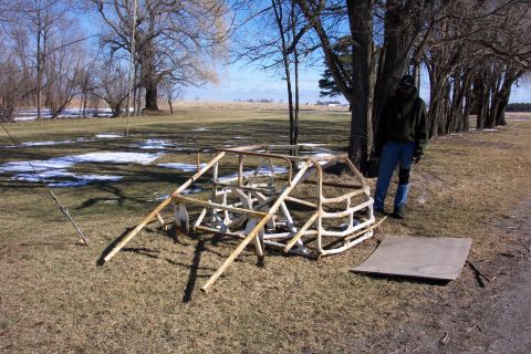 1979 Ford F-150 - A person stands next to a disassembled metal frame in a field.