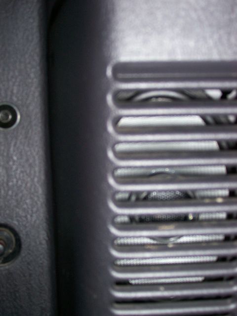 1998 Jeep TJ - A close-up view of a vehicle's interior speaker grille and surrounding textured panel.