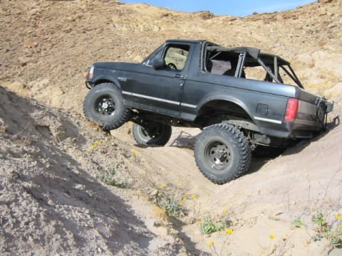 1992 Ford Bronco - This 1992 Ford Bronco is navigating a steep, sandy incline in a desert landscape.