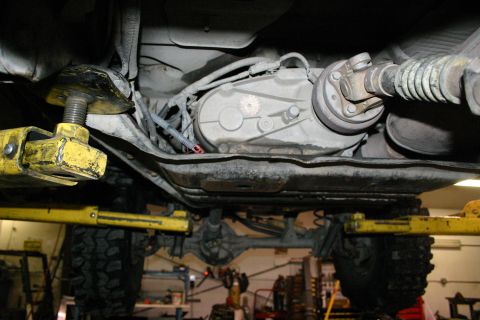 2003 Jeep TJ - The undercarriage of a vehicle is shown, highlighting the transfer case and driveshaft assembly.