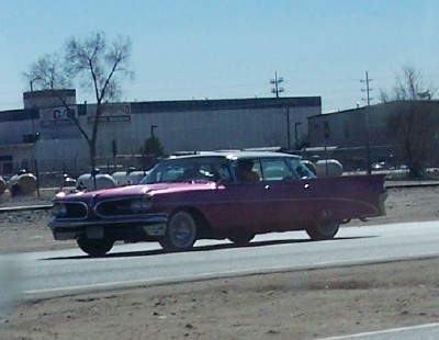 1972 Ford Ranchero - A purple 1959 Pontiac Bonneville with a white roof and whitewall tires is seen driving on a highway.