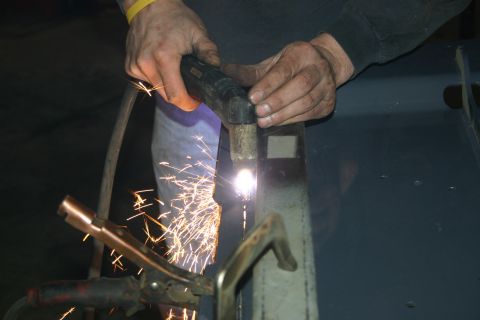 2003 Jeep TJ - Metal fabrication in progress with a plasma cutter creating sparks.