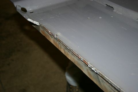 2003 Jeep TJ - Close-up of a damaged metal panel showing rust and poor welding.