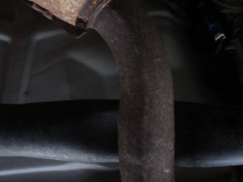 2000 Ford Crown Victoria - Close-up view of a vehicle's exhaust pipe, showing signs of rust and wear.