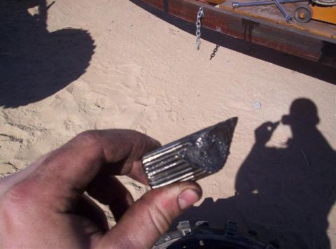 1987 Suzuki Samurai - A hand holds a greasy, splined metal part, possibly a component from a vehicle's drivetrain, with a Supermotors.net logo in the lower right…