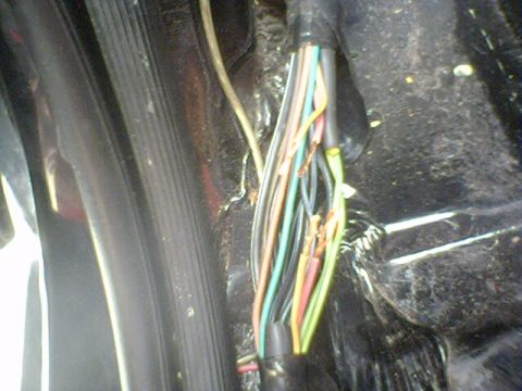 1994 Ford Bronco - Close-up of a damaged electrical wiring harness with exposed and broken wires.