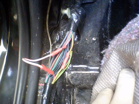 1994 Ford Bronco - Close-up of a vehicle's interior wiring harness, showing multiple wires connected with red crimp connectors.