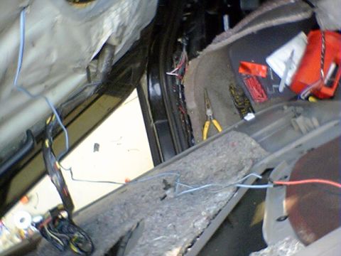 1994 Ford Bronco - The interior of a vehicle is shown with its door panel removed, revealing wiring and tools for repair.