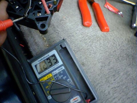 1994 Ford Bronco - A multimeter is used to test electrical connections, showing a reading of 12.33.