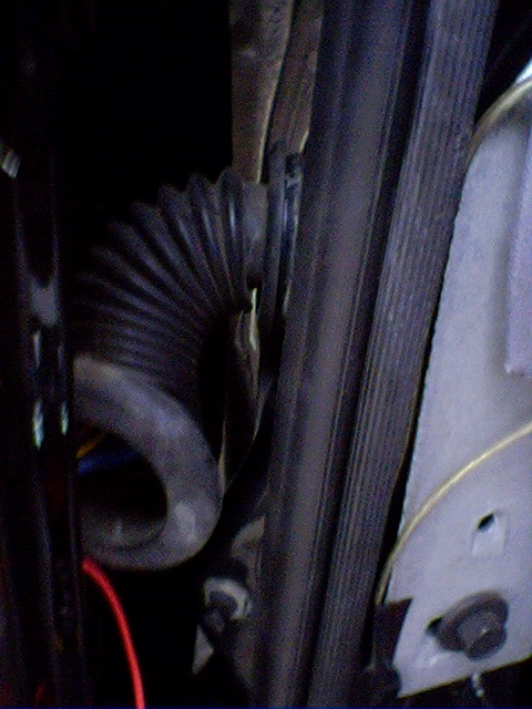 1994 Ford Bronco - Close-up view of a corrugated hose and a ribbed belt, likely part of a vehicle's engine system.