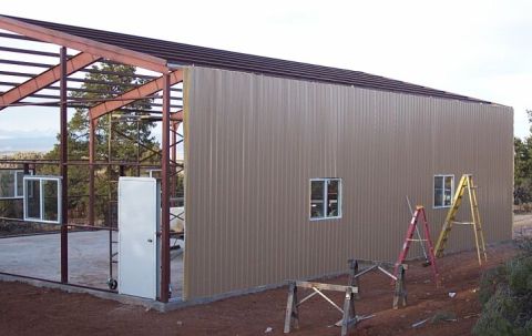 1986 Ford Ranger - A metal building under construction shows its framework and siding, with tools and materials nearby.