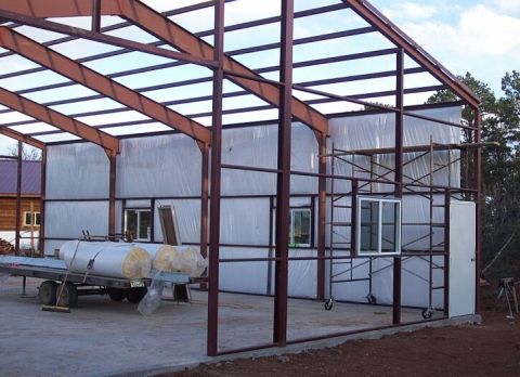 1986 Ford Ranger - A construction site shows the framework of a building with steel beams and plastic sheeting covering the walls.