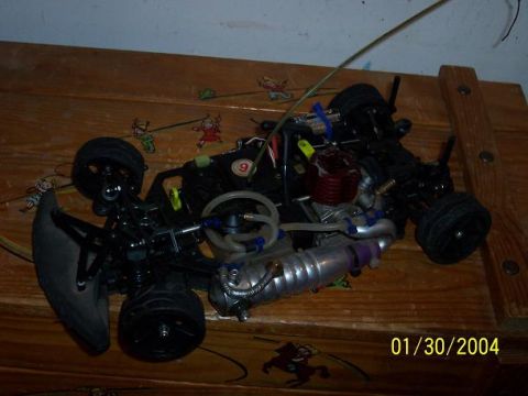 1994 Ford Probe - A remote control car with a visible engine and exhaust system sits on a wooden table.