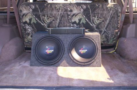 1993 Ford Bronco - Vehicle interior shows dual subwoofers and amplifier, with camouflage seat covers visible.
