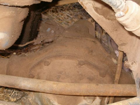 1985 Ford Bronco - Close-up of a heavily soiled rear axle housing, likely from an older vehicle.
