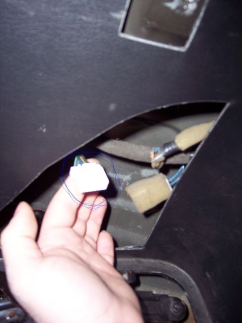 1995 Ford Probe - A hand holds a white wiring harness connector with visible wires.