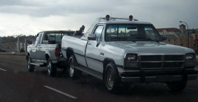 1972 Ford Ranchero - A tow truck transports a pickup truck on a cloudy day.