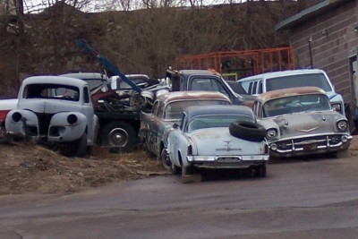 1972 Ford Ranchero - A collection of aging vehicles, including a 1957 Chevrolet, are parked together in an outdoor lot.