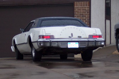 1972 Ford Ranchero - This white coupe features a distinctive spare tire cover on its rear, with a license plate visible.