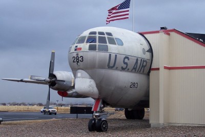 1972 Ford Ranchero - A U.S. Air Force cargo plane with the number 283 visible on its fuselage is parked outdoors next to a building.