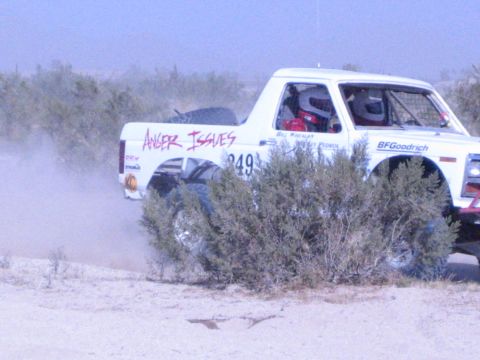 White 'Anger Issues' 949 race truck speeding through desert brush