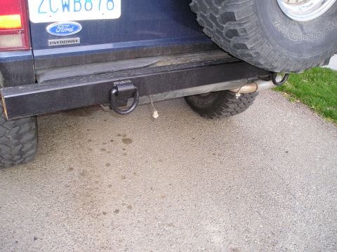 1986 Ford Bronco II - Close-up of the rear bumper and spare tire assembly on a blue SUV, a heavy-duty tow hook.